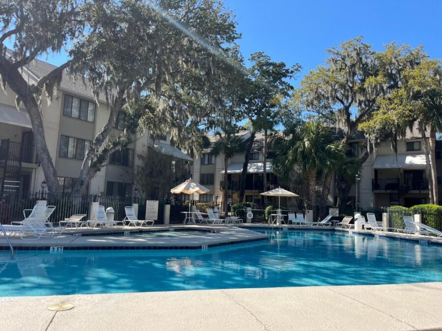 The pool at the Marriott, overlooking the beach in Hilton Head, South Carolina, surrounded by palm trees and lounge chairs.
