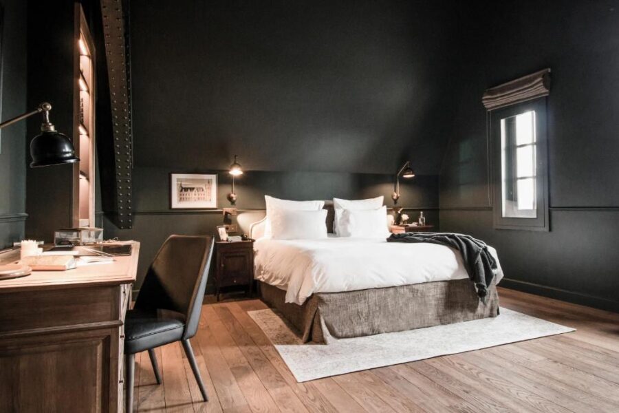 Interior of a hotel room at 1898 The Post, Ghent, showcasing a bed and a spacious window with a view.
