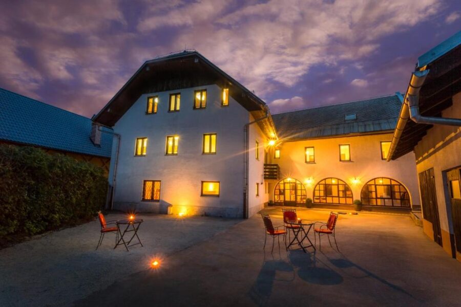 Courtyard at 1A Adventure Hostel illuminated at night, showcasing a table and chairs for outdoor relaxation.