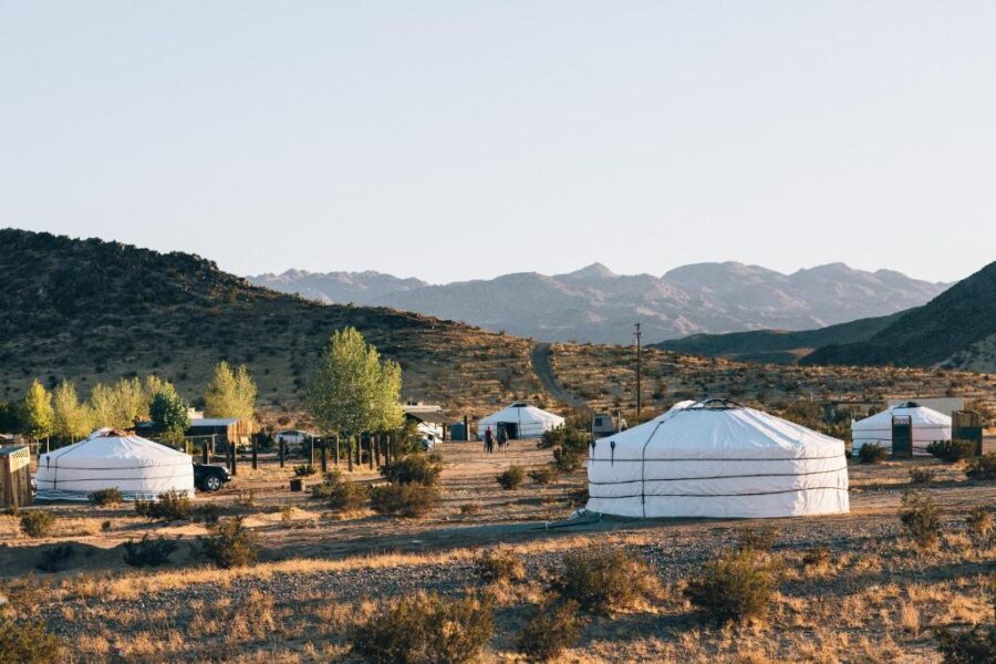 Several yurts at 28 Palms Ranch in the desert, with majestic mountains rising in the background.