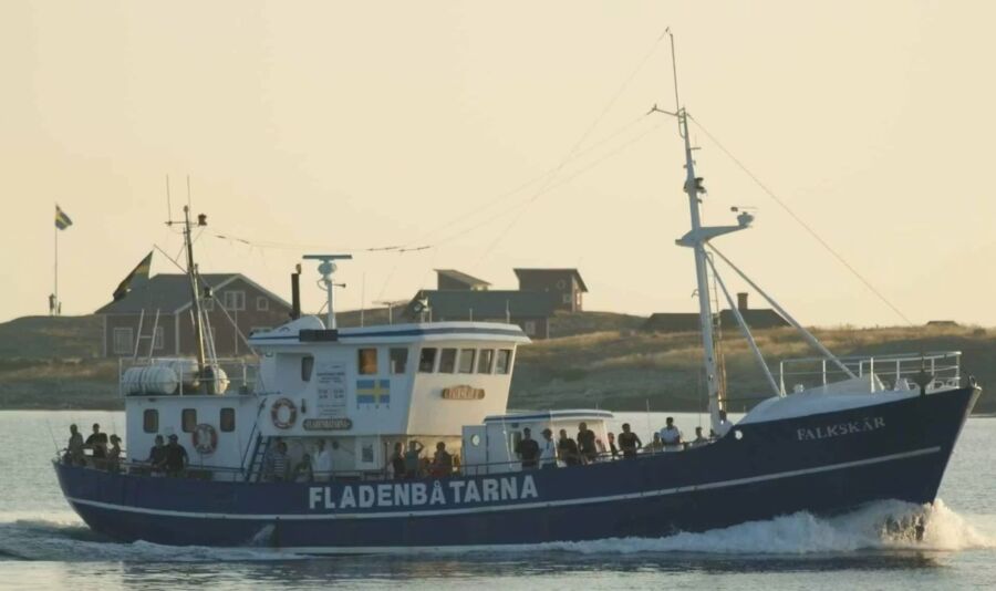 The Falkskar II, a large blue and white boat, glides over the water on an 8-hour fishing tour from Varberg.
