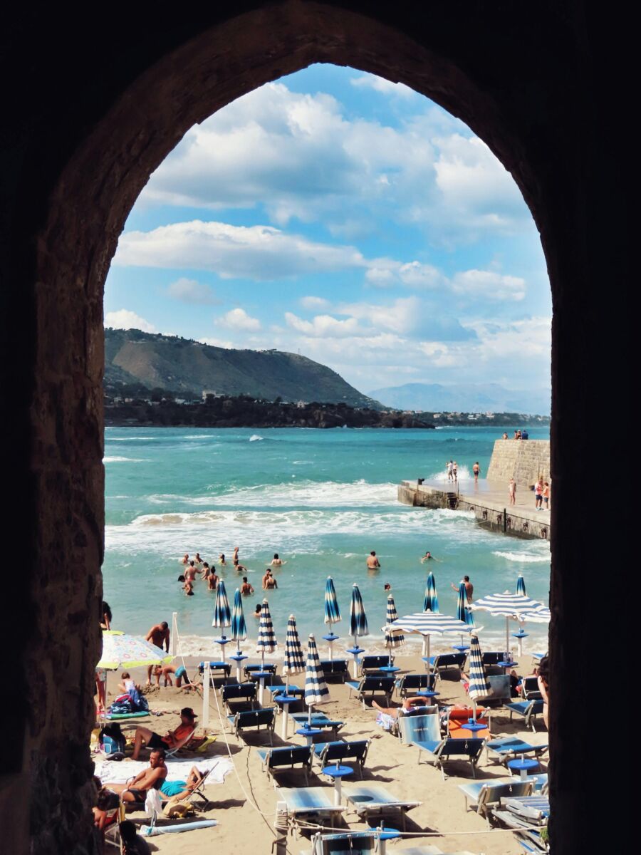 Beach goers enjoying the waters in Cefalu in Italy
