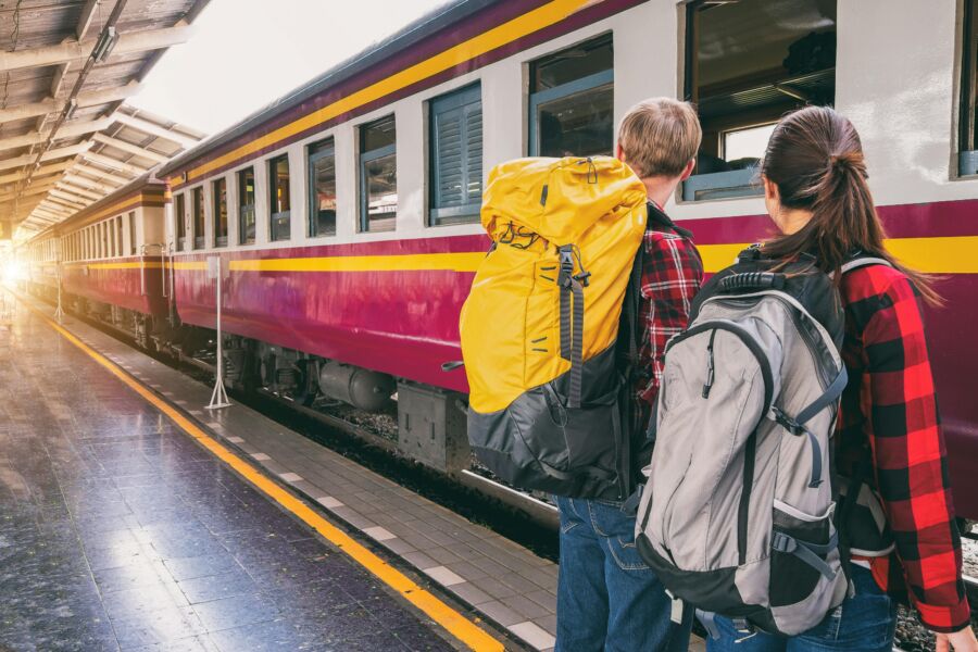 Couple backpacker waiting for train ride