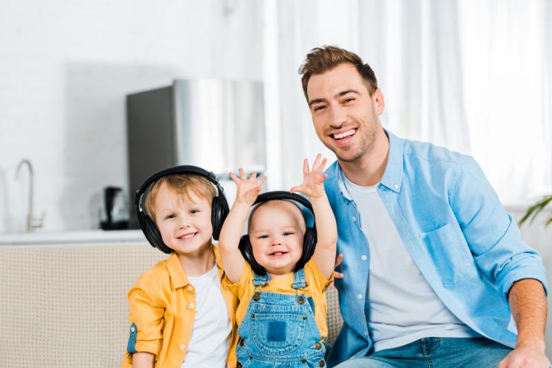 Dad smiling with kids on headphones