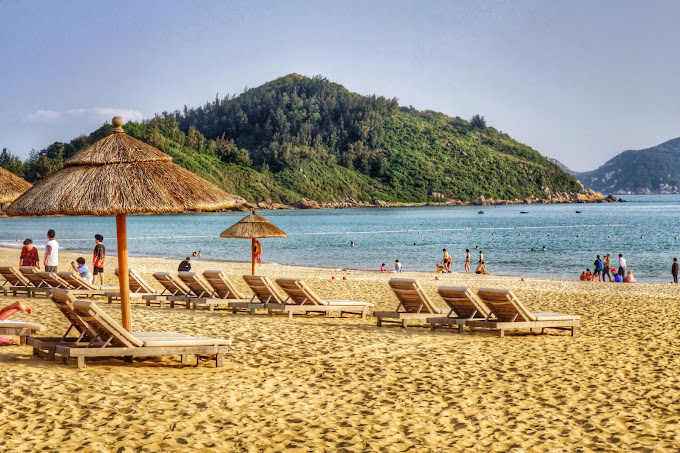 Blue waters and tourists at Shen Zhou Ban Dao Lv You Du Jia Qu