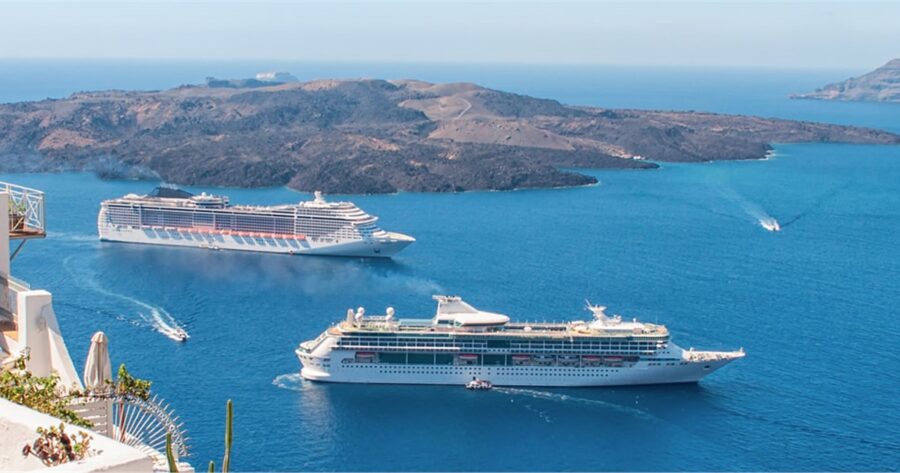 Aegean cruise ships near rocky volcanic island under blue skies.