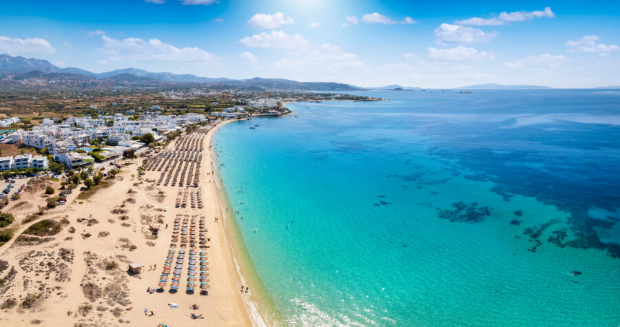 Panoramic aerial shot of Agios Prokopios beach, highlighting the stunning coastline and vibrant blue waters of Naxos, Greece.