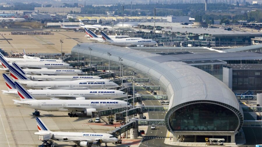 Air France jets at Paris Charles de Gaulle airport terminal, showcasing modern architecture and bustling operations.