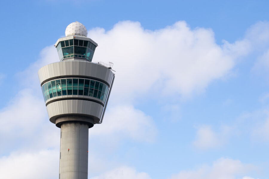 Air control tower stands tall against a vibrant skyline, symbolizing aviation and urban development
