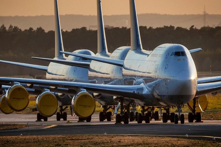 Sunset-lit commercial aircraft on runway, showcasing engineering, readiness, and modern aviation marvels.