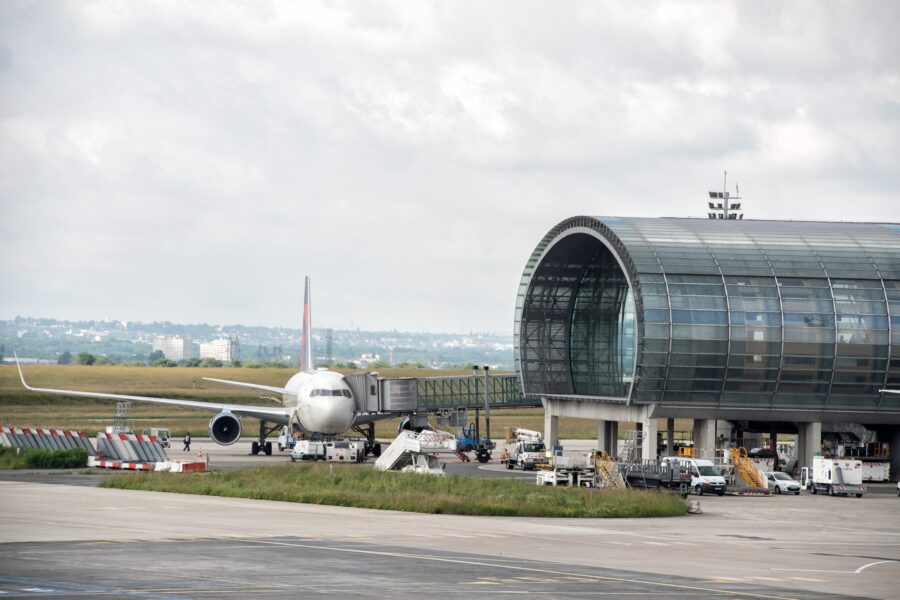 Busy airport scene with airplane at terminal, showcasing operations and infrastructure.
