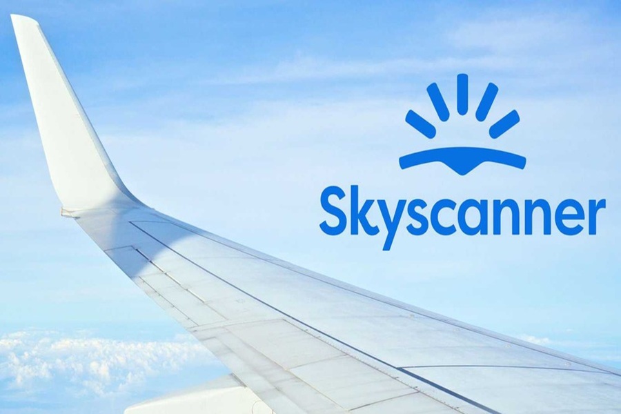 Airplane wing and Skyscanner logo against blue sky, symbolizing travel and exploration.