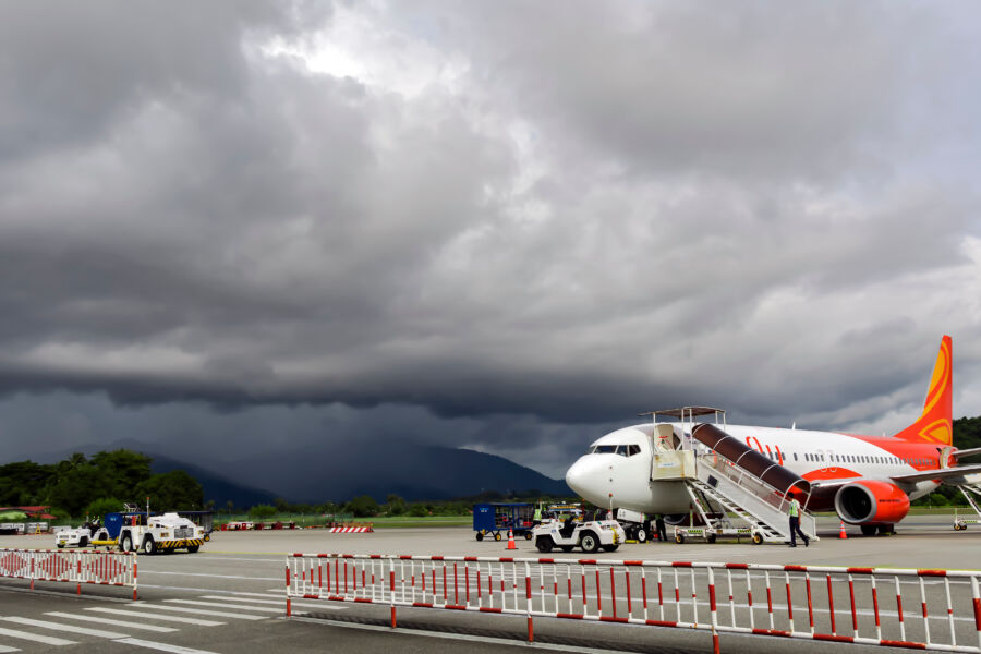 Airplane with dark storm clouds gathering looming in the background