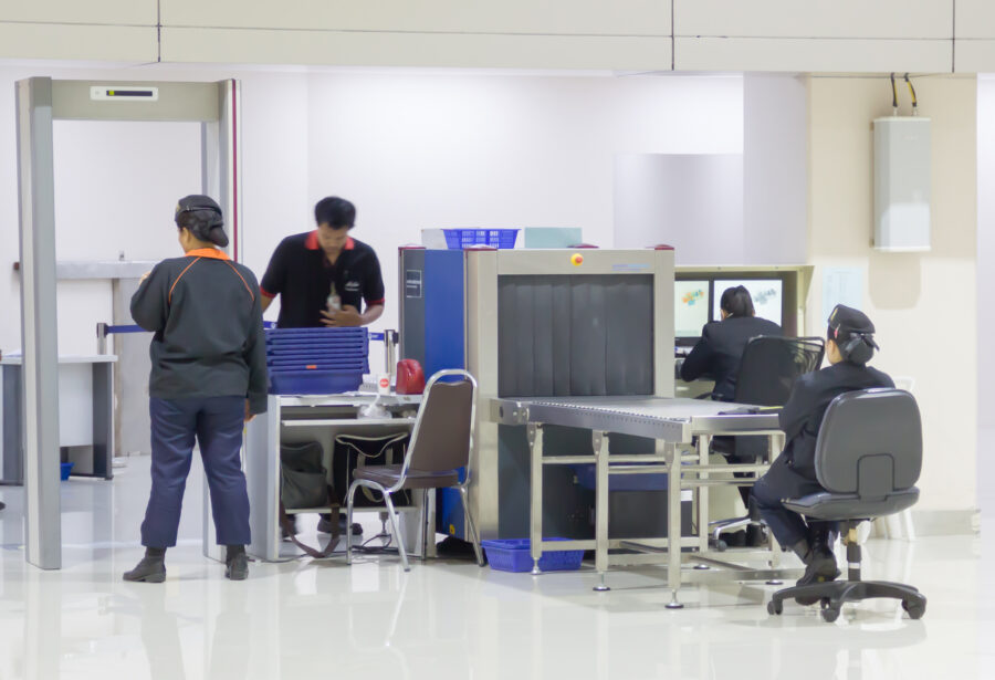 Security gates with metal detectors and scanners at the entrance of an airport, ensuring passenger safety and screening.
