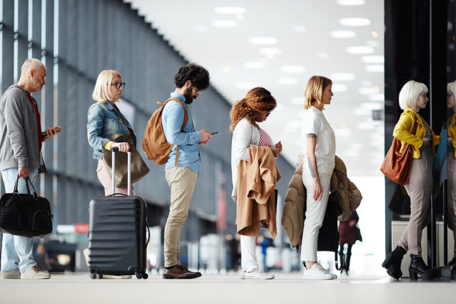 Close-up of multiracial people in queue standing to get through the airport check in