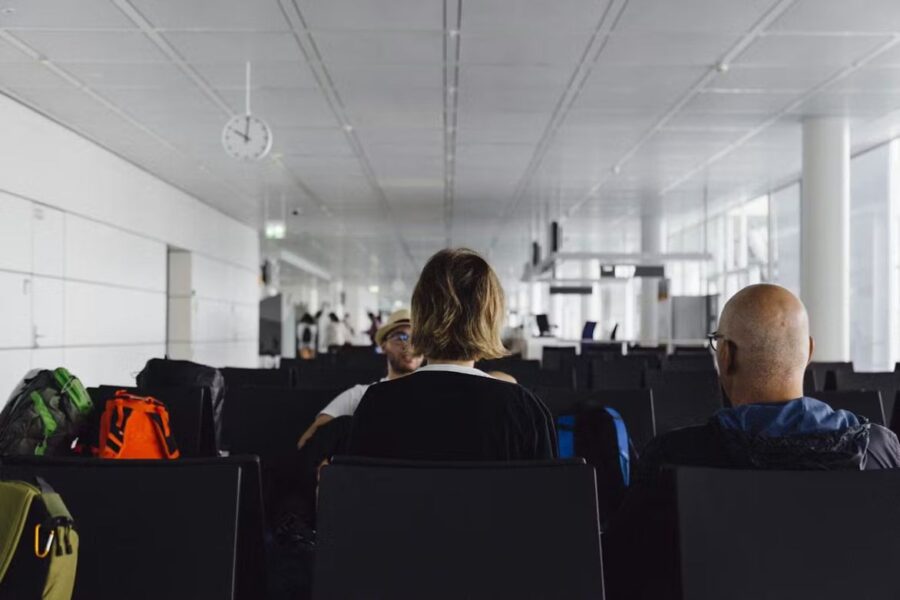 Travelers in modern airport terminal waiting area during layover at Munich Airport.