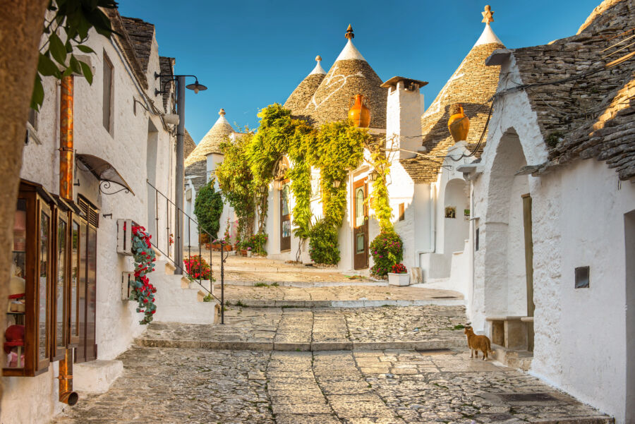 The unique Trulli houses of Alberobello alongside a beautiful church, showcasing the charm of Apulia, Puglia, Italy