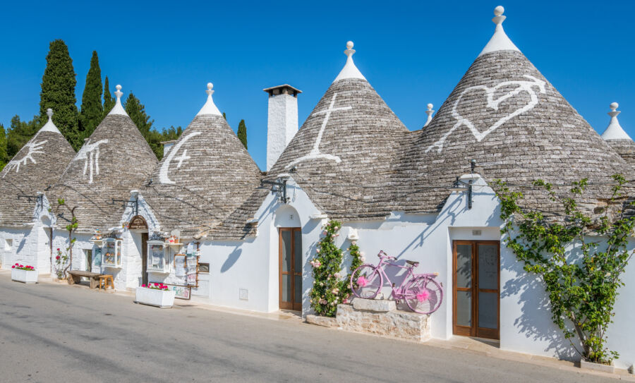 Scenic view of Alberobello, showcasing the iconic Trulli houses in Apulia, southern Italy, under a clear blue sky