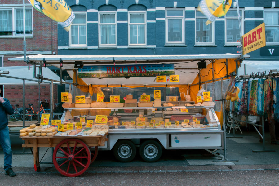 Vibrant cheese stand at the Albert Cuyp Market in Amsterdam, showcasing a variety of cheeses and local delicacies