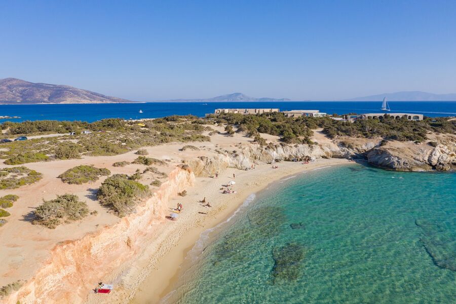 Aliko Beach in Kalymnos, Greece, showcasing soft sand, turquoise waters, and lush greenery along the shoreline.