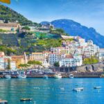 Panoramic view of beautiful Amalfi on hills leading down to coast, Campania, Italy. Amalfi coast is most popular travel and holiday destination in Europe. Ripe yellow lemons in foreground.