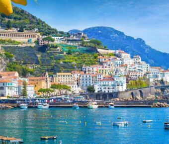 Panoramic view of beautiful Amalfi on hills leading down to coast, Campania, Italy. Amalfi coast is most popular travel and holiday destination in Europe. Ripe yellow lemons in foreground.