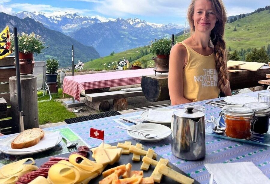 Outdoor dining with Swiss cheeses and meats against a stunning mountain backdrop.