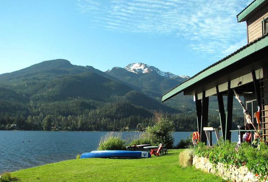 House surrounded by a lawn featuring a boat, located by Alta Lake in Whistler, British Columbia, Canada.