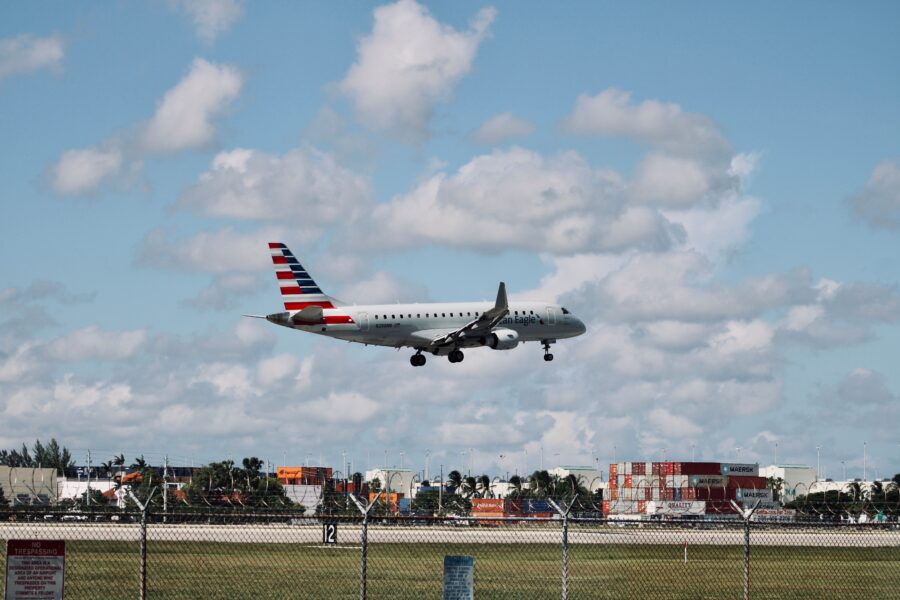 An American Airlines airplane flying low over the runway at Miami International Airport during landing.