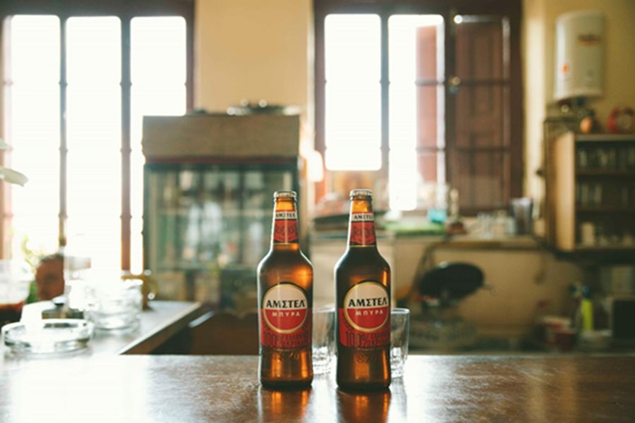 Cozy bar setting with Amstel beer bottles and glasses, ideal for relaxation and enjoyment.
