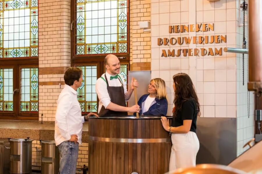 Visitors exploring the Heineken Experience in Amsterdam, engaging with displays about beer production and the brand's heritage.