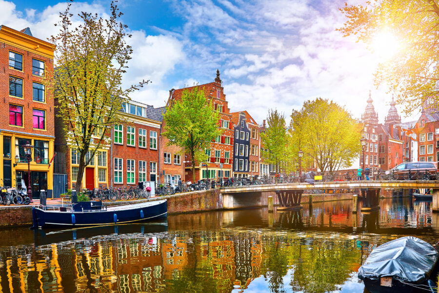 Scenic canal in Amsterdam featuring the historic Amstel River and charming houses along its banks.