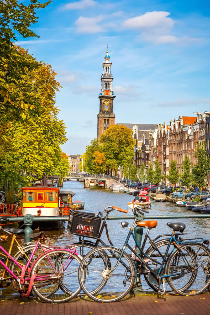 Traditional old buildings and boats line the canals of Amsterdam, showcasing the city's historic architecture and charm.