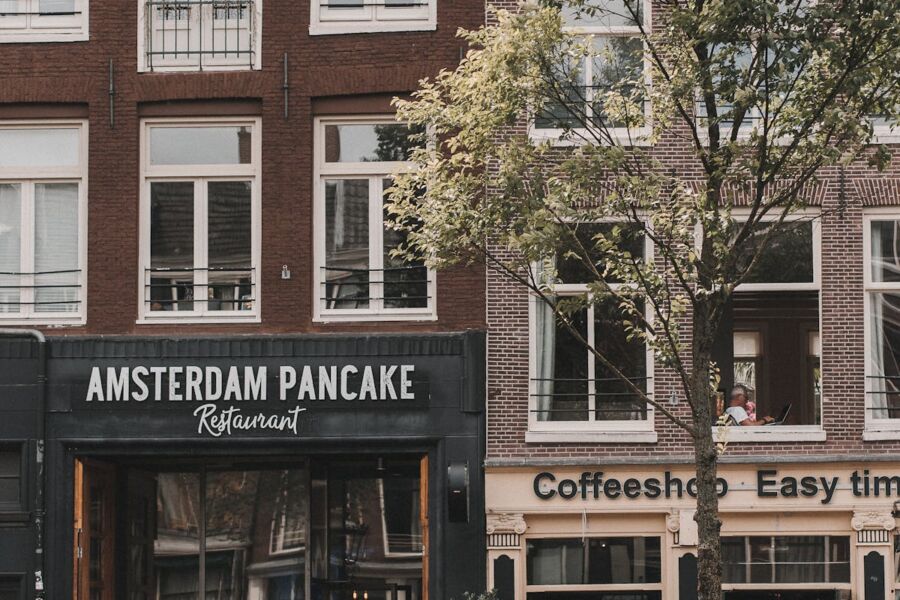 Amsterdam street scene with pancake restaurant and coffeeshop, capturing urban culture and architecture.