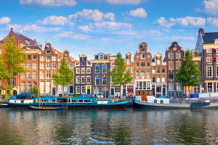 Scenic view of Amsterdam's city center showcasing historic houses and charming bridges along the canals.