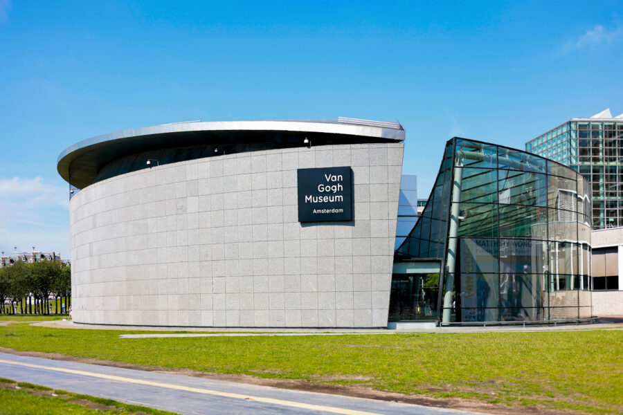 Exterior view of the Van Gogh Museum in Amsterdam, showcasing its modern architecture and surrounding greenery