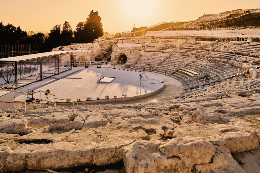 Ancient amphitheater at sunset, blending historic architecture with modern stage elements.