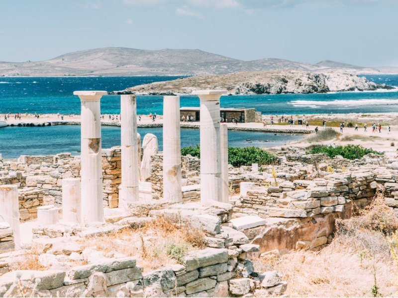 Delos Island ancient ruins with coastal marble columns overlooking the Mediterranean Sea.
