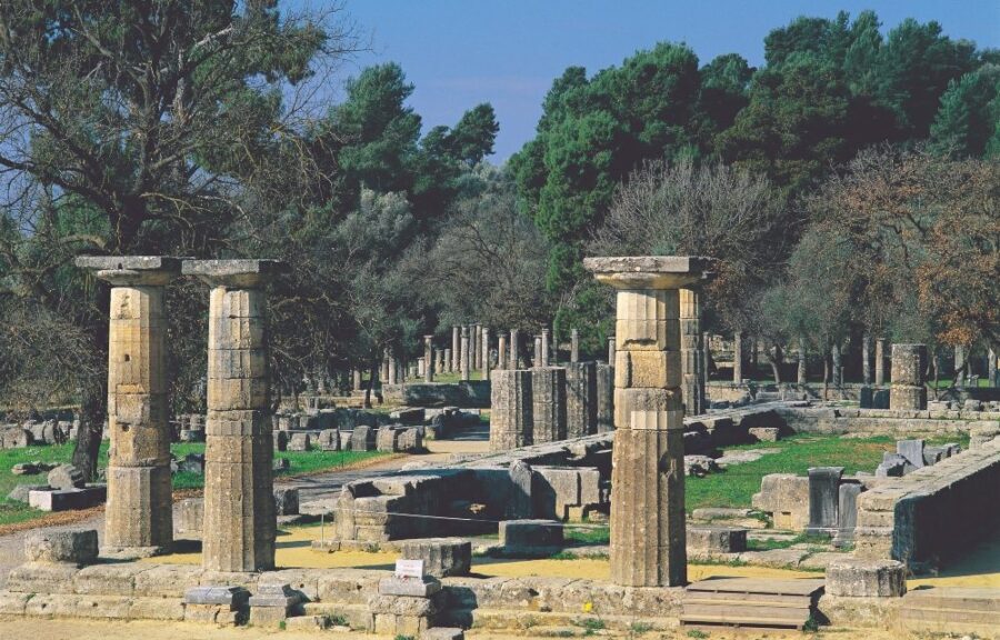 Ancient Olympia ruins with fluted limestone columns at archaeological site in Greece.