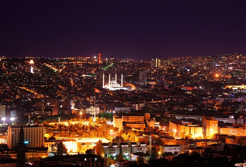 Ankara Turkey skyline illuminated at night, showcasing its historic architecture and vibrant city lights against a dark sky.
