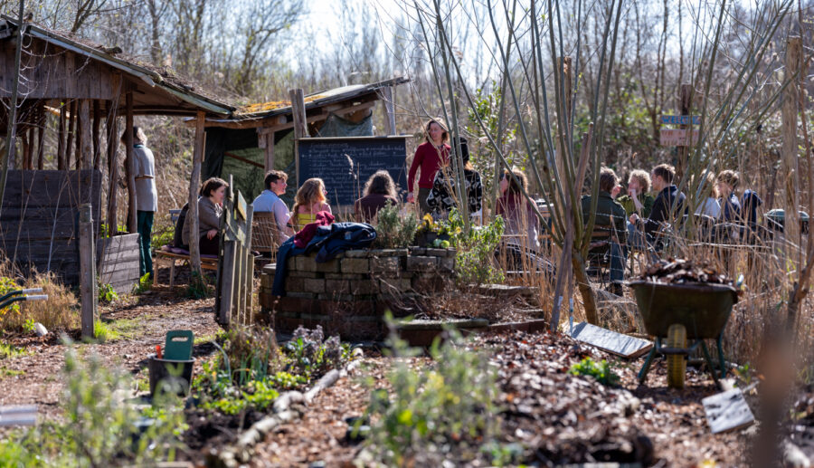 People standing together in a lush garden at Anna’s Tuin & Ruigte, Amsterdam, enjoying the outdoor setting.