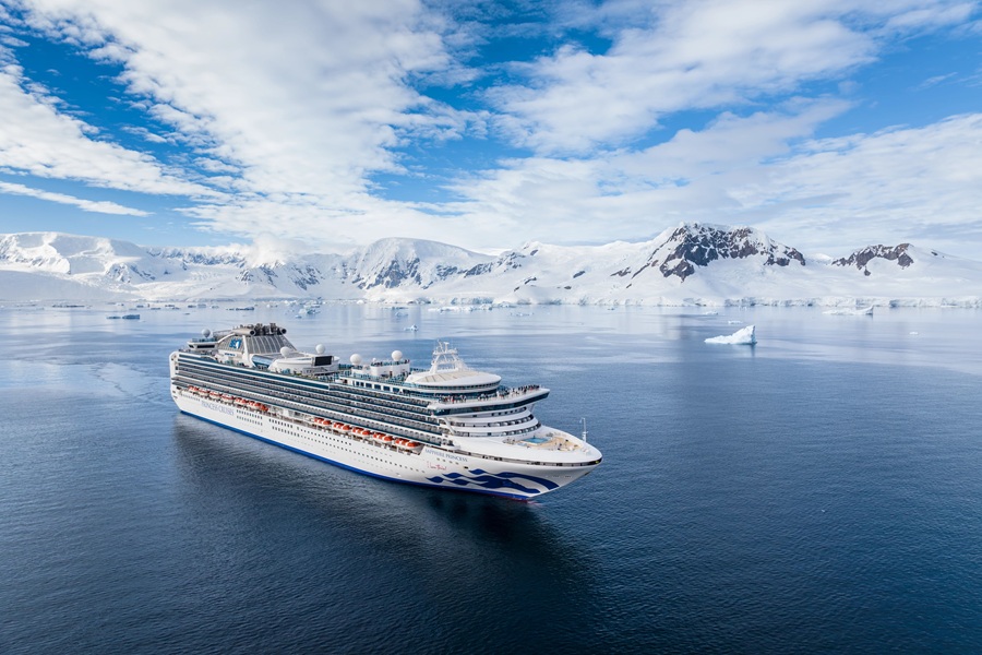 Cruise ship in Antarctic waters surrounded by icy mountains and glaciers.
