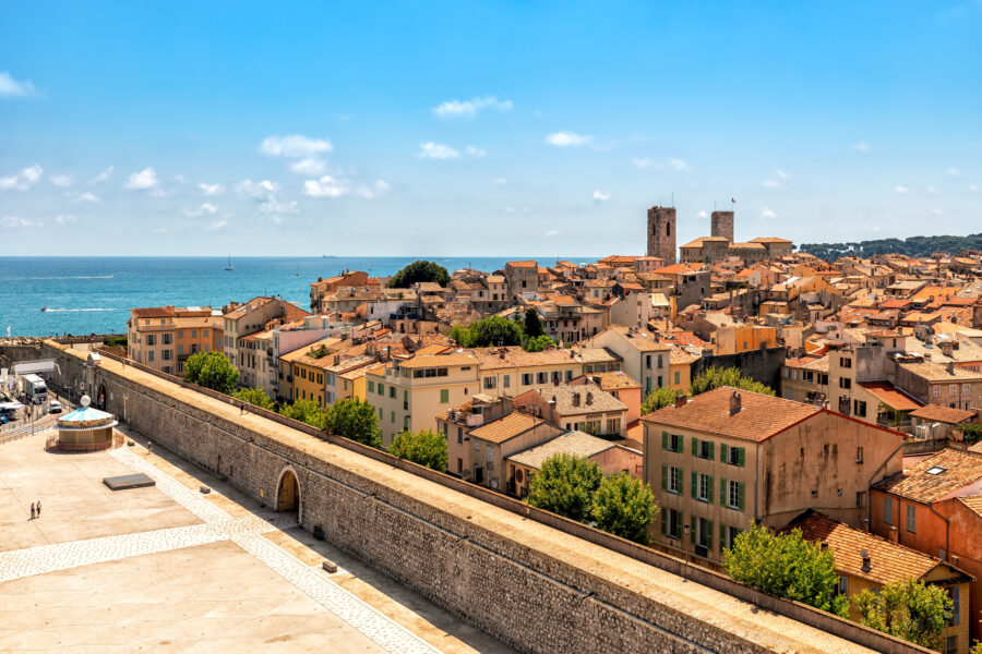 Panoramic view of Antibes, France, featuring its charming skyline with coastal buildings and the Mediterranean Sea in the background.