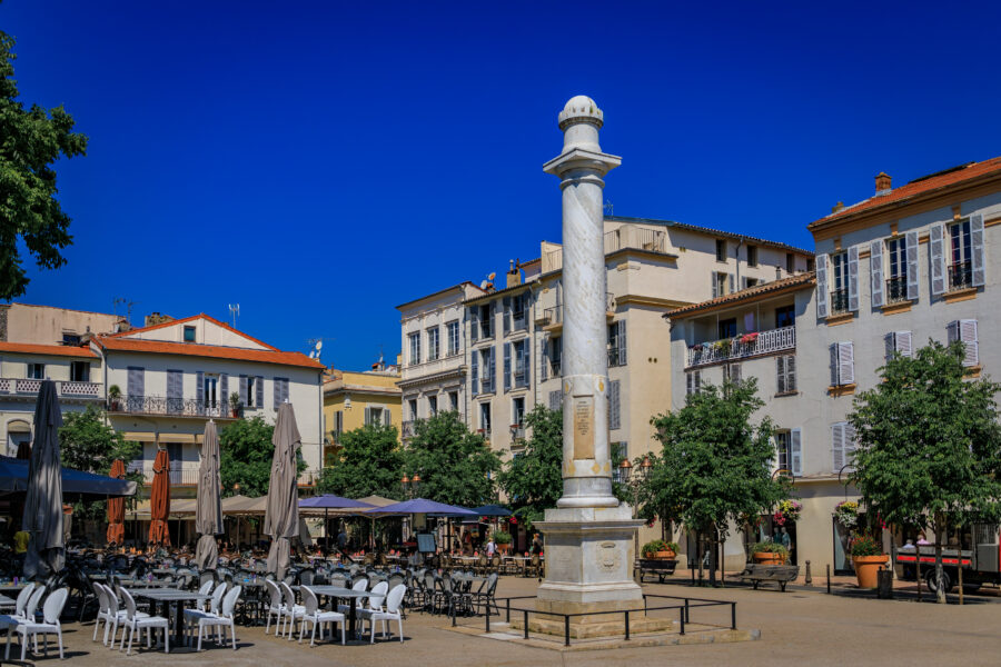 Antibes outdoor restaurant with a marble column gifted by Louis XVIII, located on Place Nationale near the Provencal market.