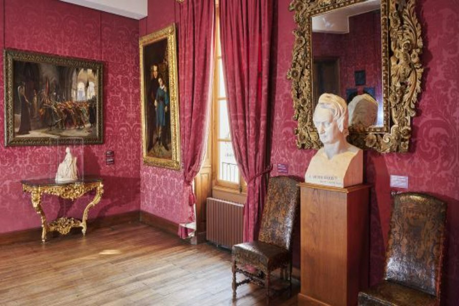 Victor Hugo apartment antique salon with red damask walls, gilt frames, marble bust.