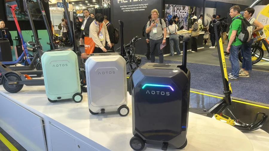 AOTOS smart rideable luggage showcased as electric robotic suitcases at a mobility trade show.