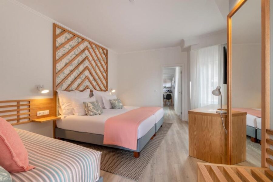 Hotel room at Aqua Natura Bay, Madeira, featuring two beds and a wooden headboard.
