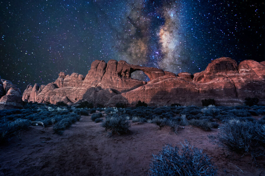 Arches National Park illuminated by a star-filled Milky Way night sky in Moab, Utah, showcasing natural rock formations