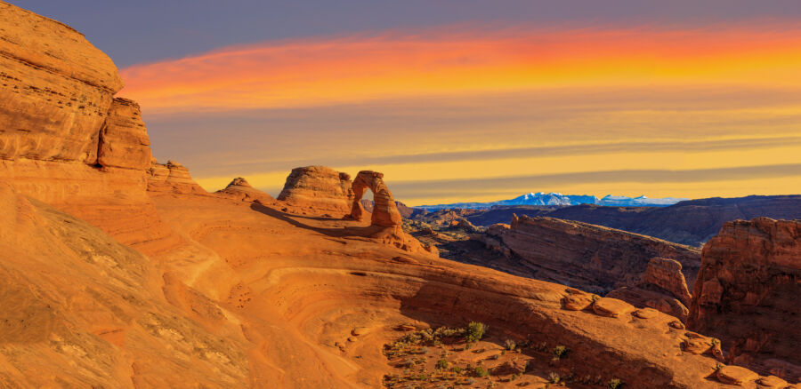 Stunning sunset panorama at Arches National Park, showcasing colorful skies over the park's famous rock arches and formations
