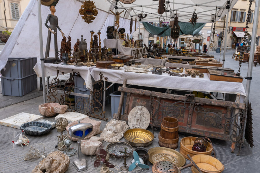 Vibrant street stalls at Arezzo's antiques market, displaying an array of unique vintage treasures and artifacts.
